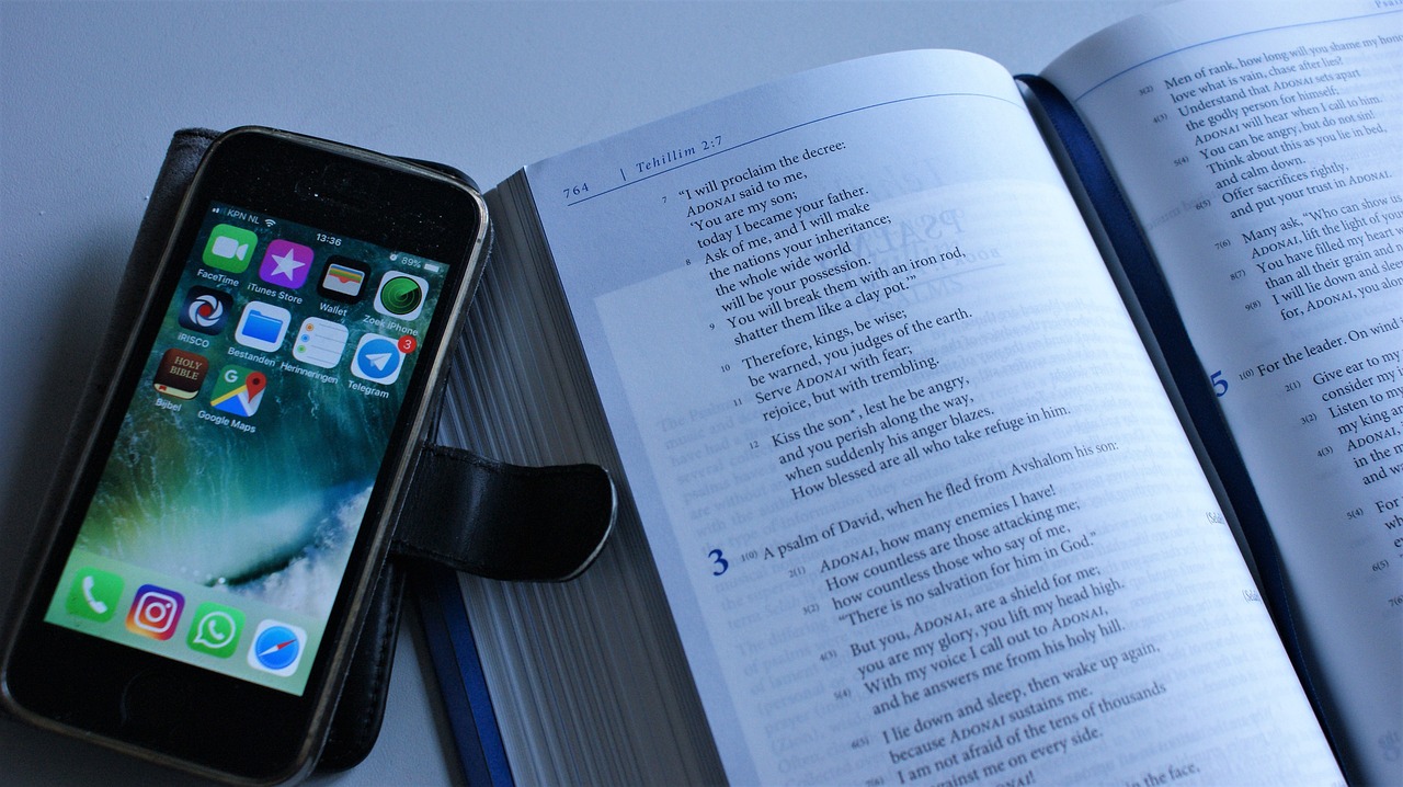 A cell phone next to an open book.